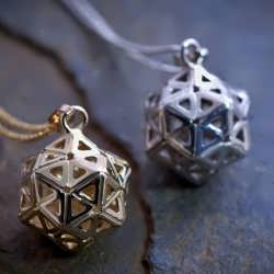 A small silver and gold Consciousness Grid pendants