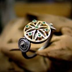 A gold and oxidized silver "KA" ring set with emeralds